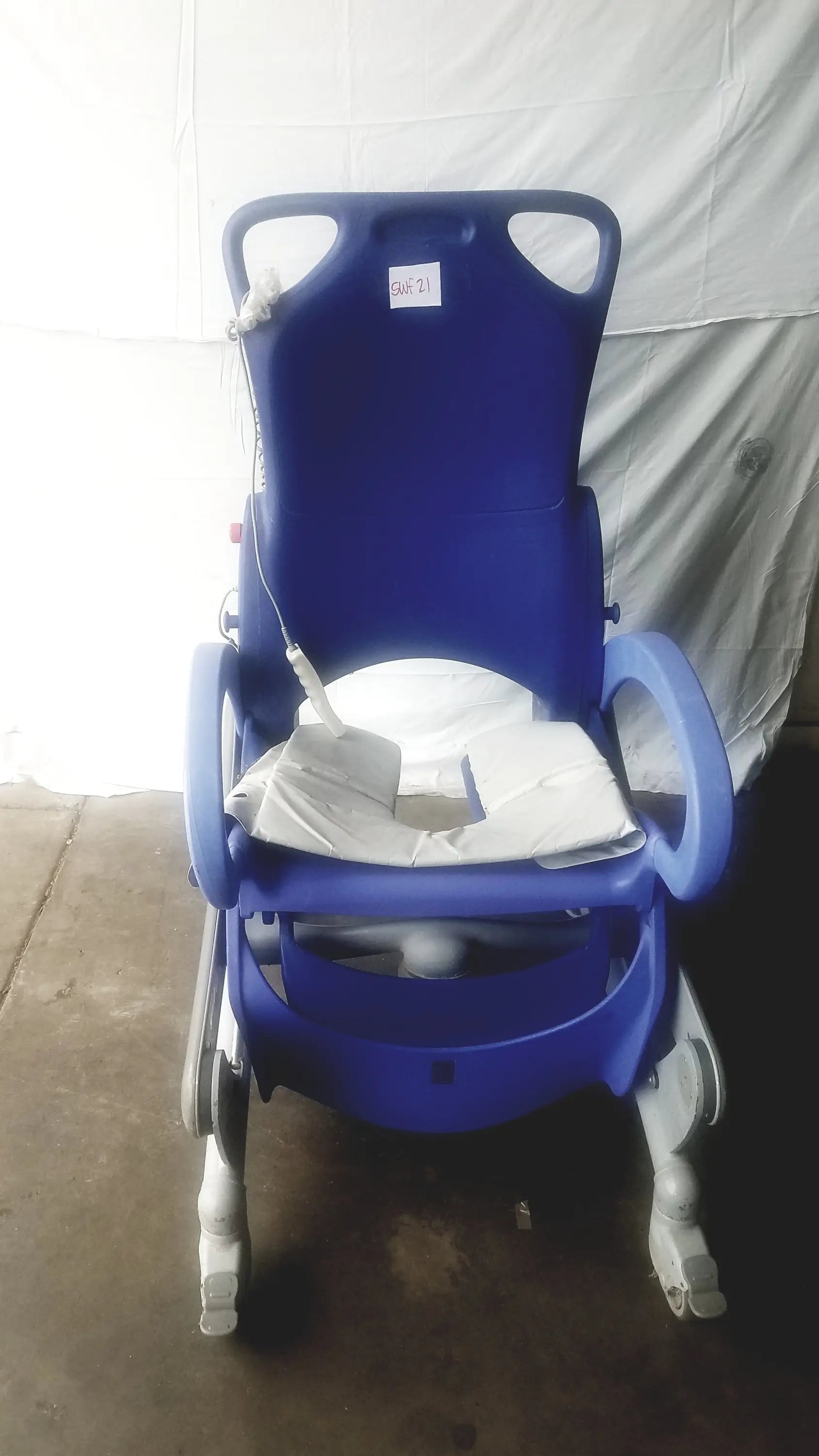 Blue plastic multipurpose hygiene chair with white cushion and casters by arjo carendo for patient care