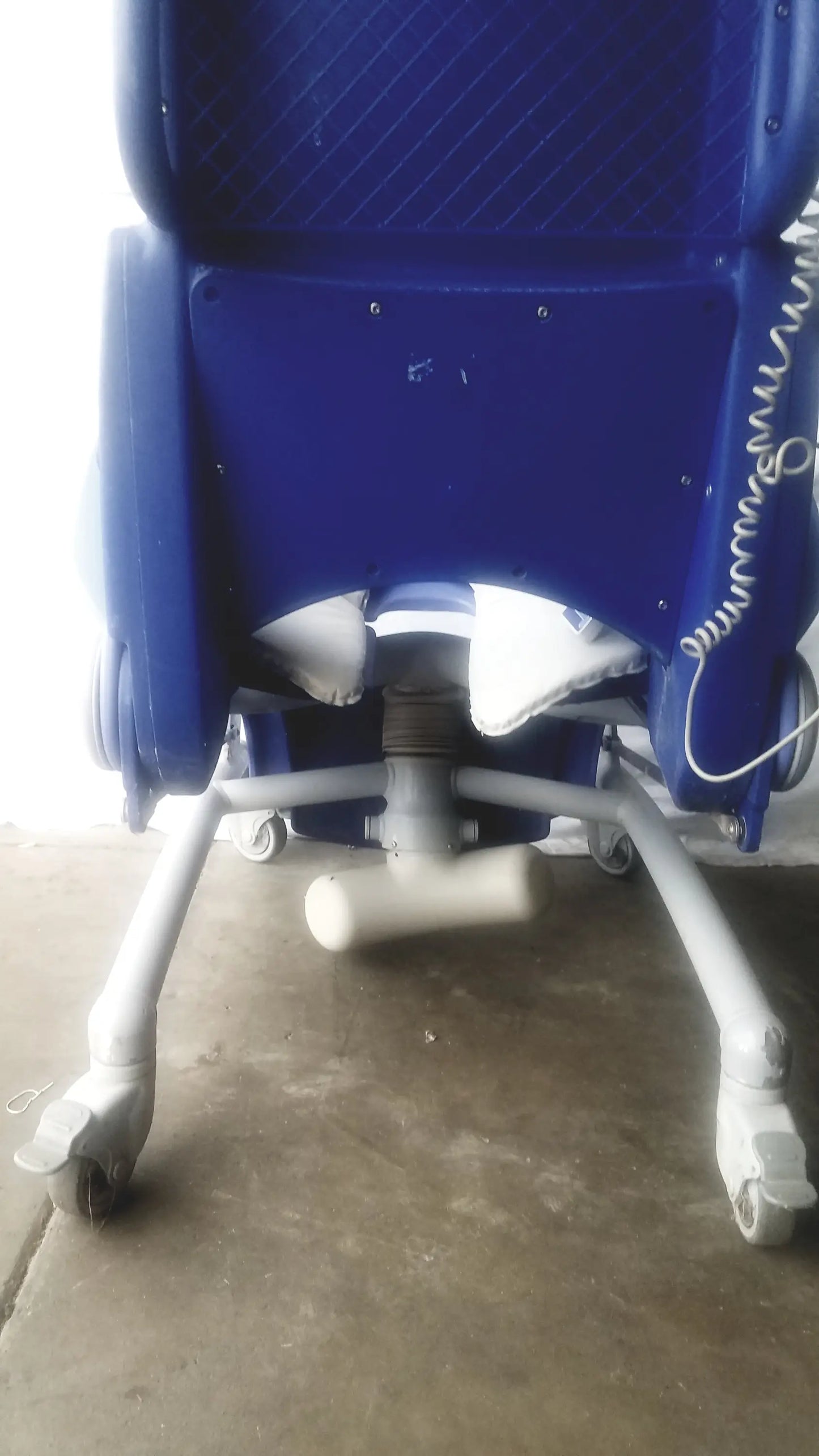 Blue plastic arjo carendo multipurpose hygiene chair with white wheels and coiled cable for efficient hygiene use