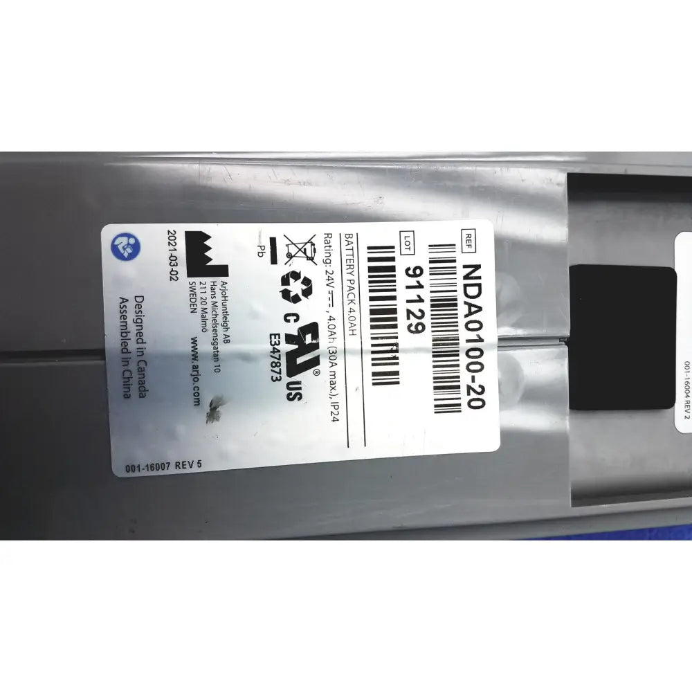 Silver rectangular lithium-ion battery pack with black label showing specifications for arjo huntleigh ab lead acid battery