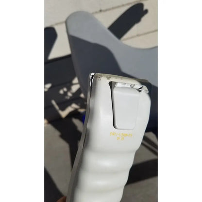 White plastic handheld device with textured grip and yellow labeling on arjo huntleigh power electric walker lift