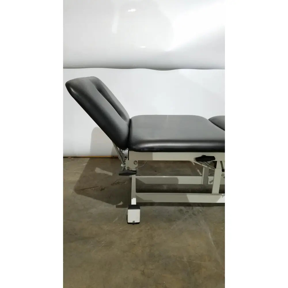 Armedica am-300 black leather three section treatment table with metallic frame and caster wheels for adjustable care