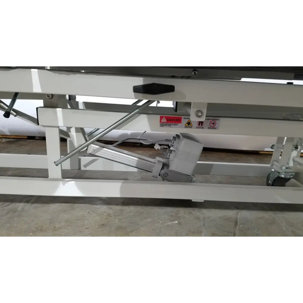 White metal hospital bed lift mechanism with gray motor housing and black handle for armedica am-300 three section treatment table