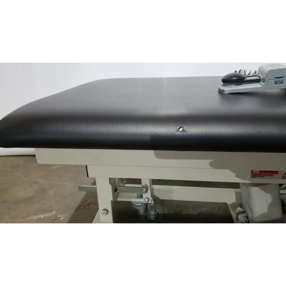 Black padded surface on white metal frame of the Armedica AM-300 three section treatment table