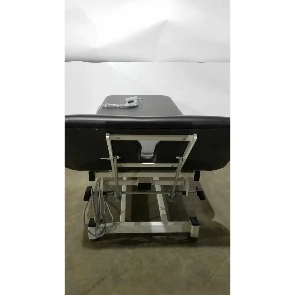 Armedica AM-300 black padded three section treatment table with silver metal frame and adjustable height mechanism
