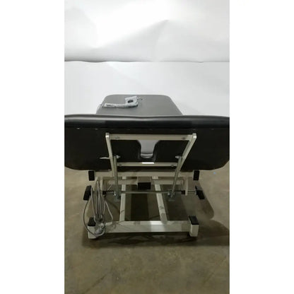 Armedica AM-300 black padded three section treatment table with silver metal frame and adjustable height mechanism