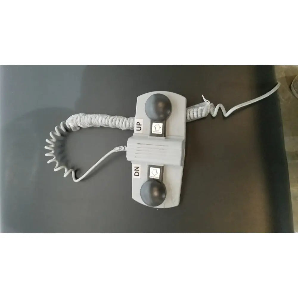 Gray plastic elevator call button panel with up and dn buttons on armedica am-300 three section treatment table
