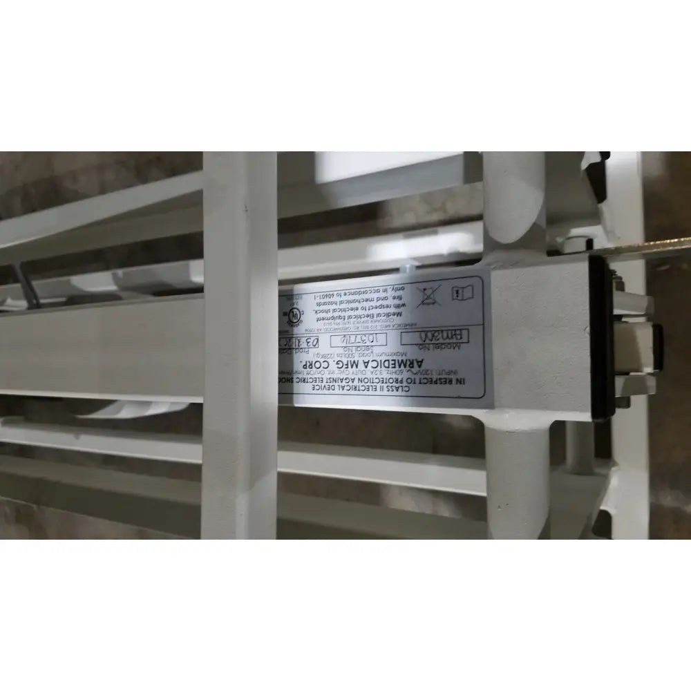 White label with black text on the back of an Armedica AM-300 three section treatment table electrical component