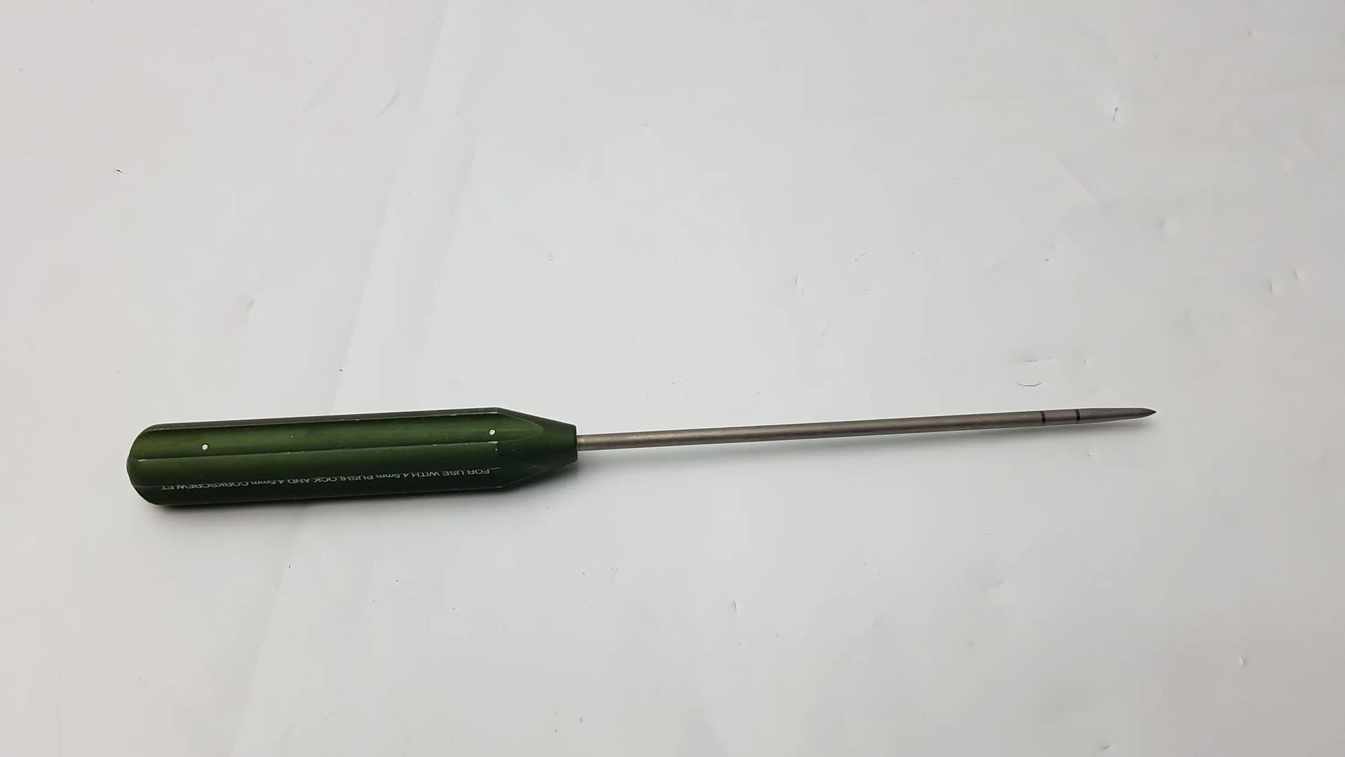 Green-handled ar-1922p surgical instrument with slender metallic shaft and pointed tip for corkscrew ft systems use