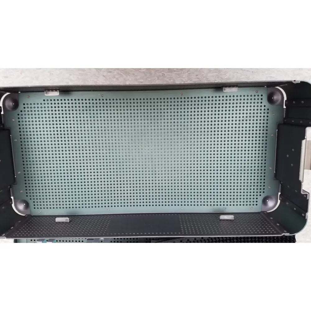 The interior of a black perforated metal sterilization tray with a greenish-gray mesh from the ArthroCare AutoCuff OPUS collection
