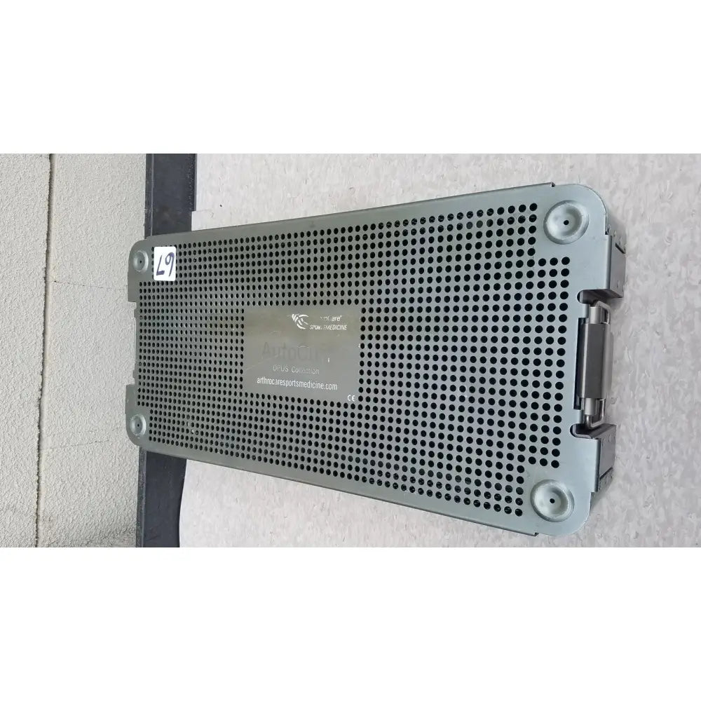 Gray perforated metal autocuff opus collection sterilization tray with hinged lid and corner latches for surgical instruments
