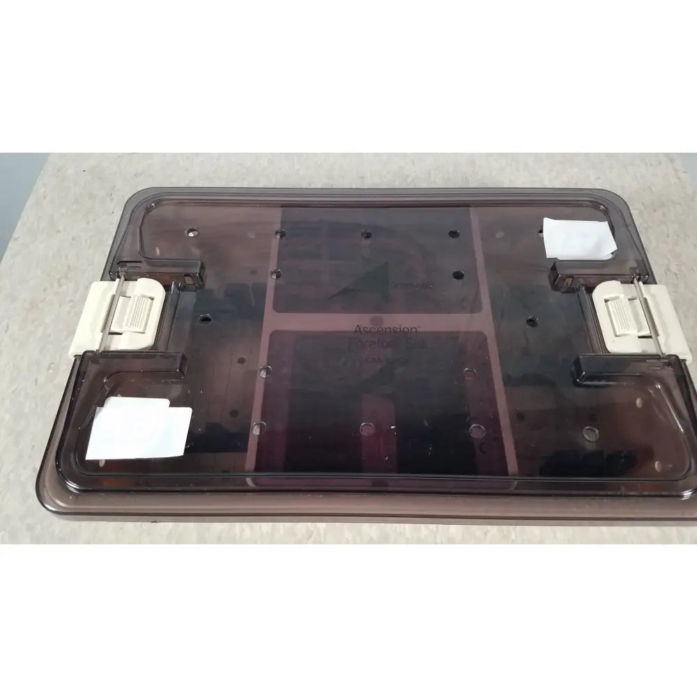 Transparent brown plastic lid with white latches and internal compartments of the ascension forefoot set ref csa-800-01