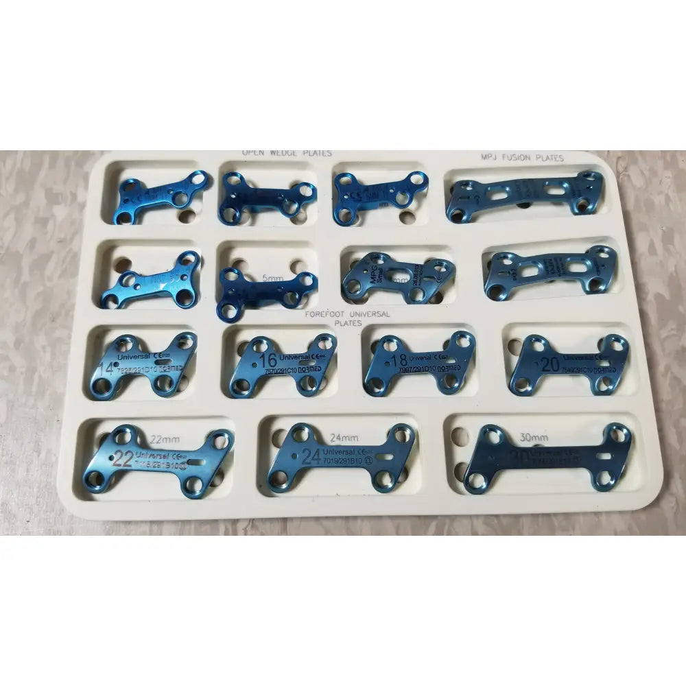 Blue metallic surgical plates in a white tray labeled with size and type from the ascension forefoot set ref csa-800-01