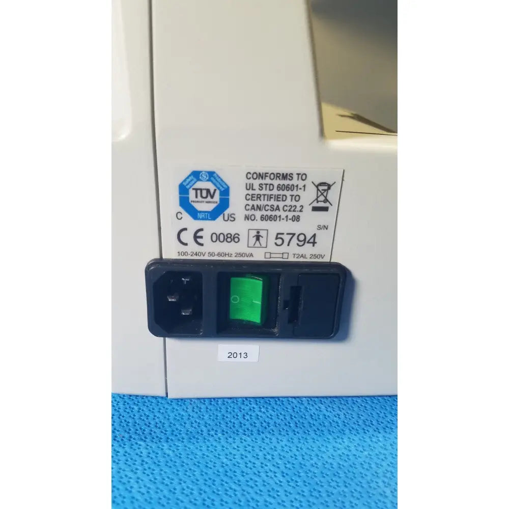 Black power input panel with green illuminated switch and certification labels on the back of audioscan verifit vf-1 hearing analyzer