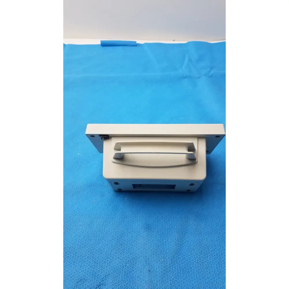 Beige plastic cash register drawer with handle and mounting brackets for secure automatic blood pressure monitor setup
