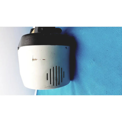White and black cylindrical security camera with ventilation slits on variable speed grinder-polisher 120v back side