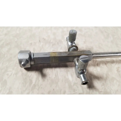 Silver metallic bainha externa richard wolf 8853.05 surgical instrument with textured knobs and central marked bar
