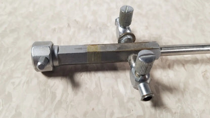 Silver metallic bainha externa richard wolf 8853.05 surgical instrument with textured knobs and central marked bar