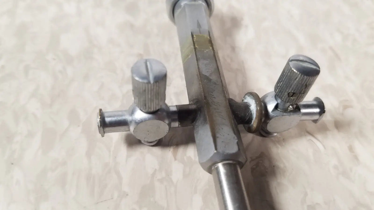 Silver metallic drum key with textured knobs and hexagonal shaft for bainha externa richard wolf 8853.05