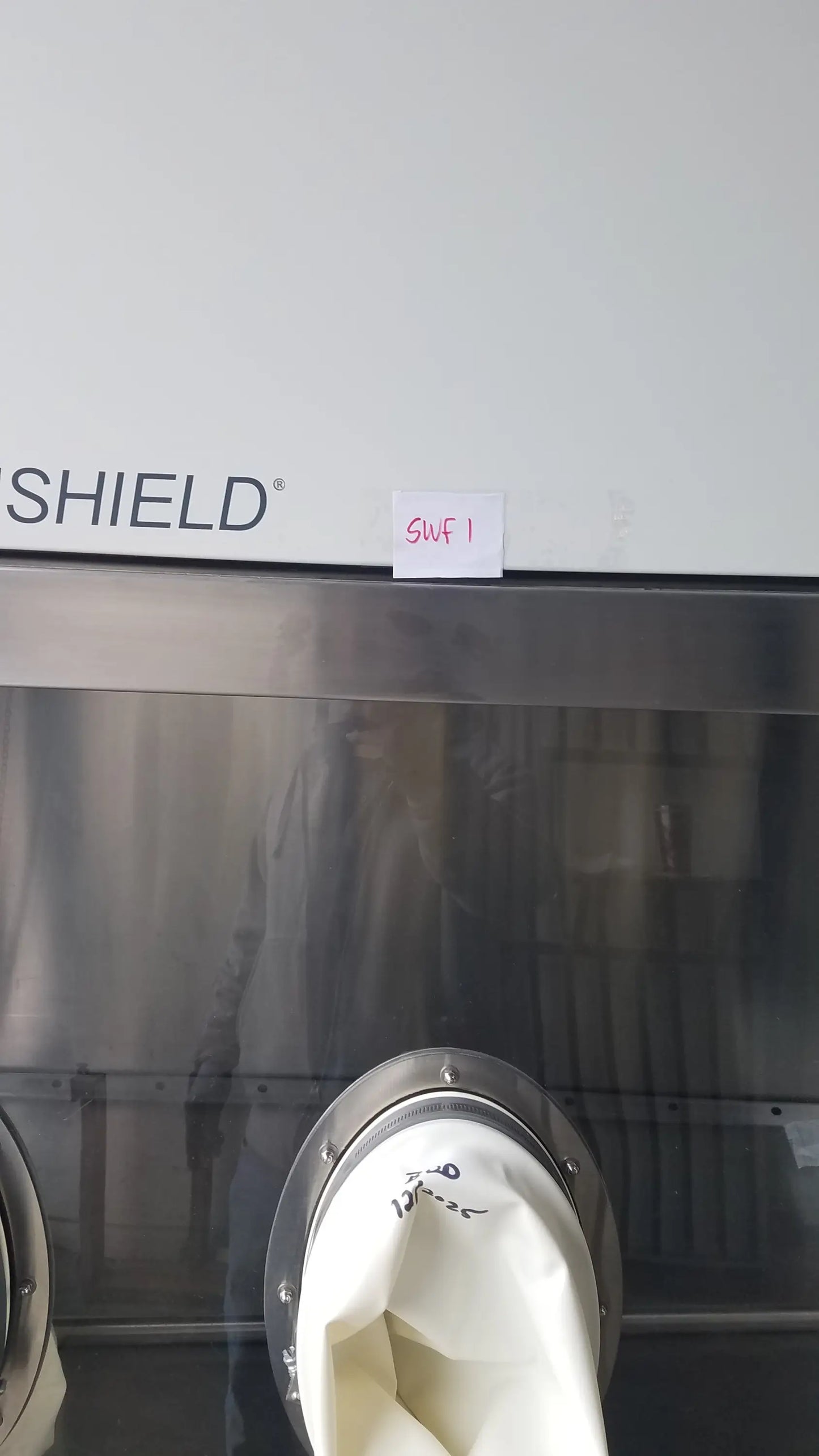 White fabric bag with metallic rim and black markings inside baker ss-600 sterilshield positive pressure isolator