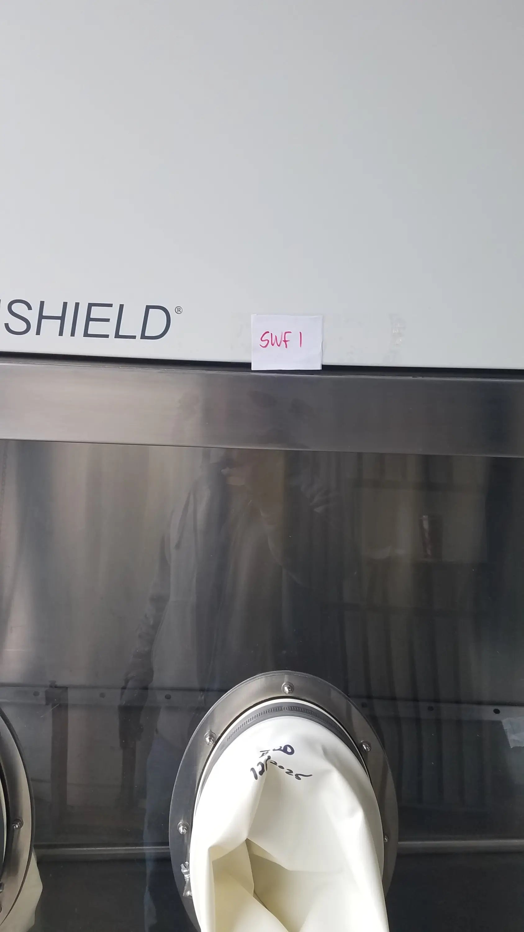 White fabric bag with metallic rim and black markings inside baker ss-600 sterilshield positive pressure isolator