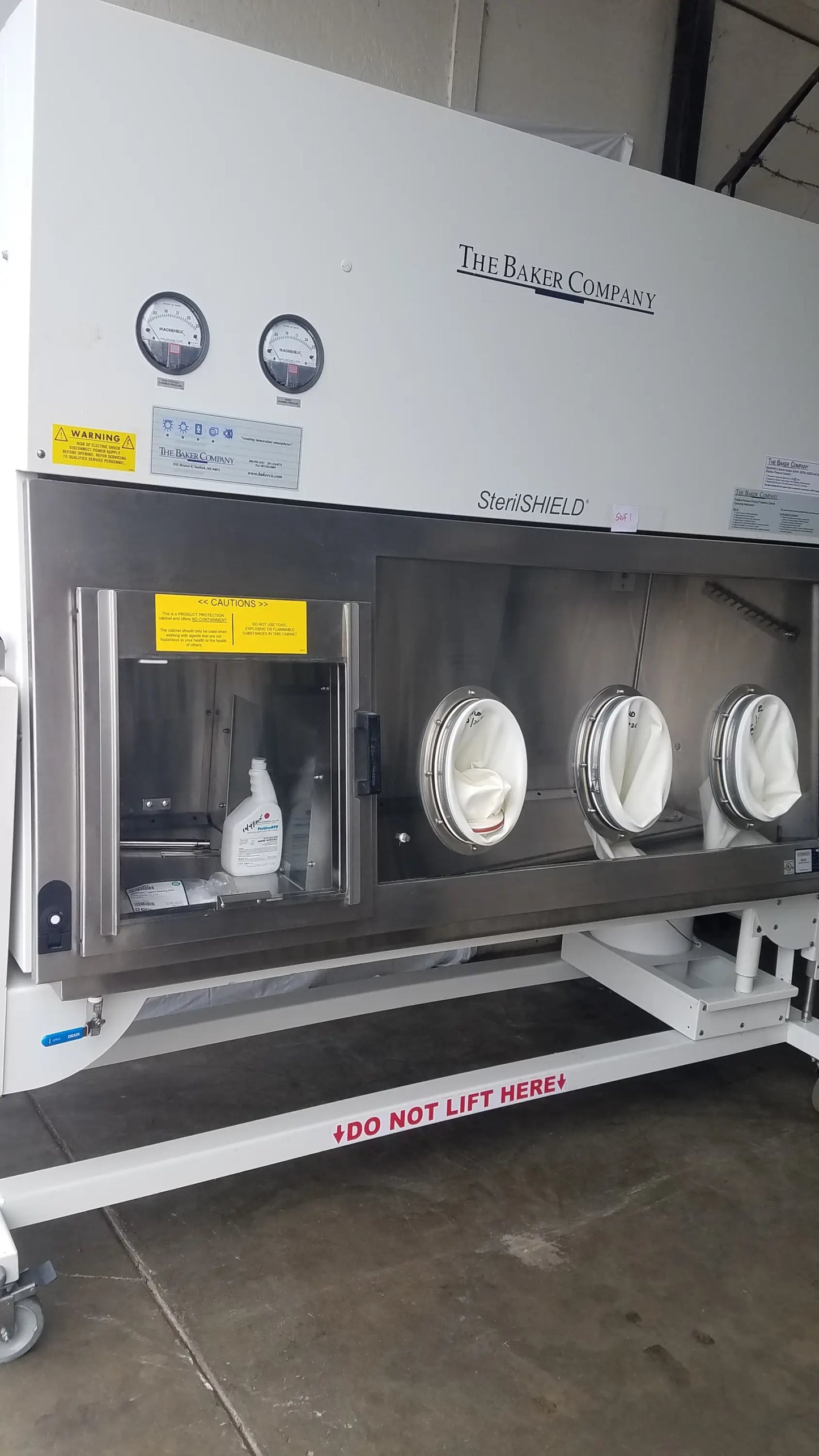 White and stainless steel baker ss-600 sterilshield positive pressure isolator with three circular glove ports and white gloves