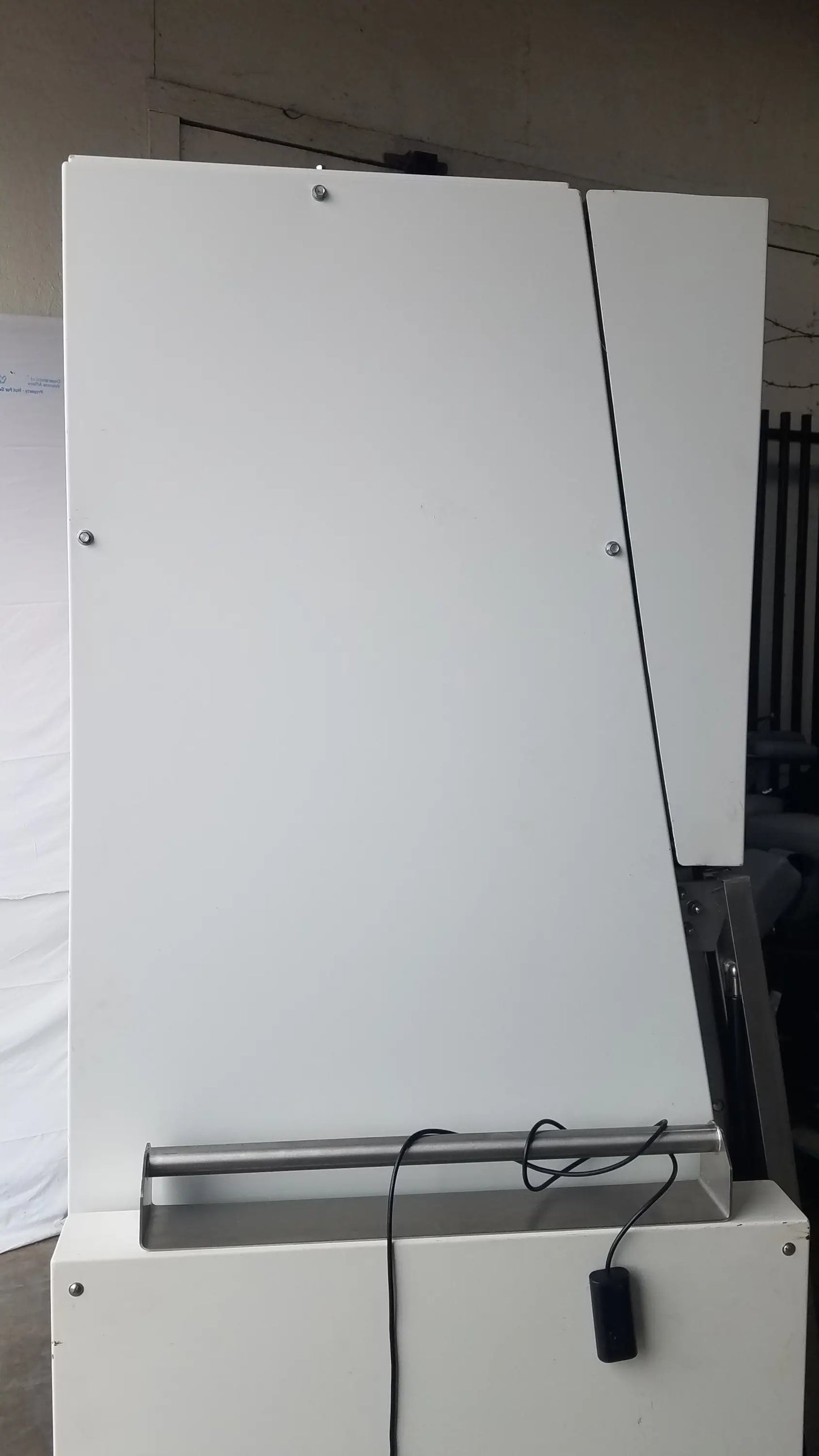 White industrial paper cutter with metallic handle and black cord for baker ss-600 sterilshield positive pressure isolator