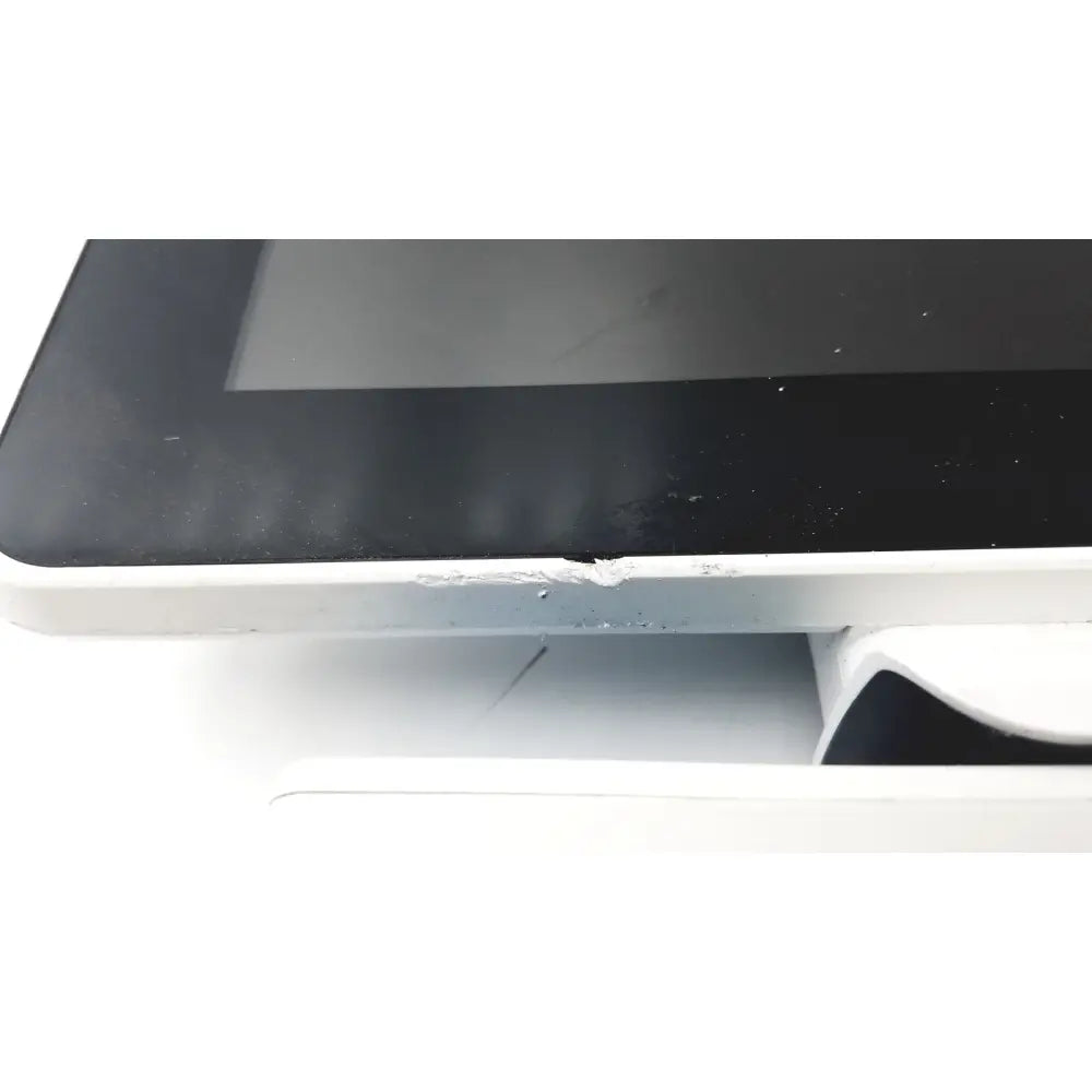 White-framed barco ja018 smart terminal with black touchscreen and adhesive residue for bedside multi-touch use