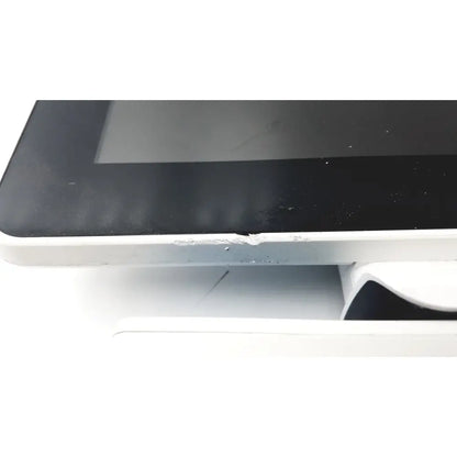 White-framed barco ja018 smart terminal with black touchscreen and adhesive residue for bedside multi-touch use