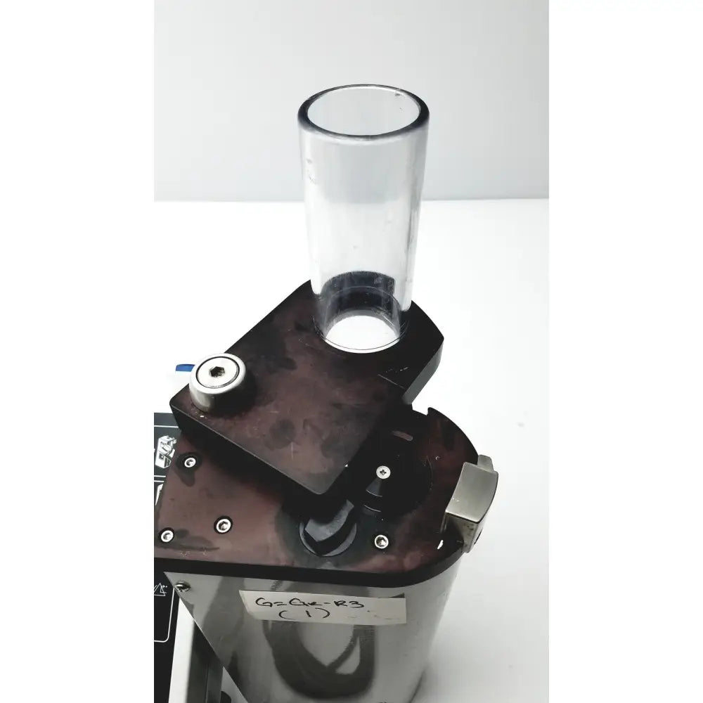 Clear cylindrical glass tube mounted on black metal base with silver screws and tag for bard peripheral flowmate injector crosser