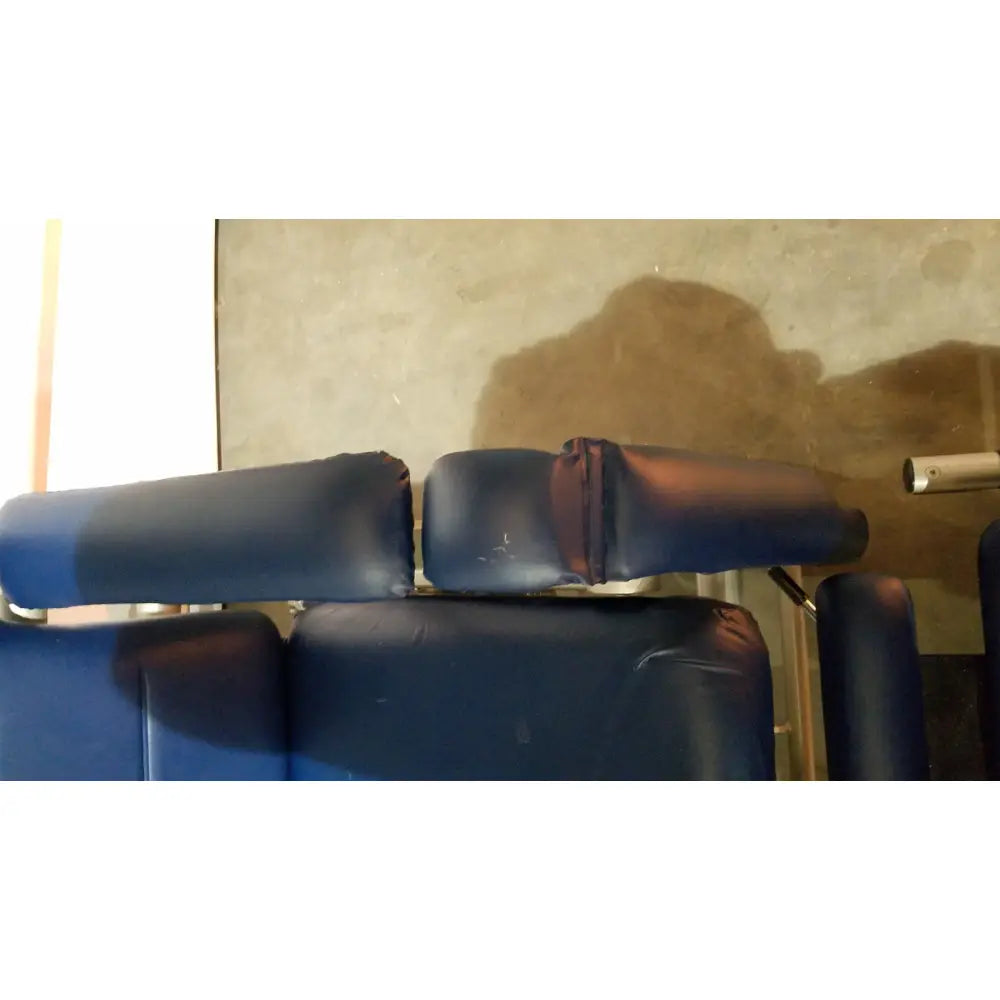 Blue padded headrest with worn dark vinyl finish on barton convertible medical chair back side