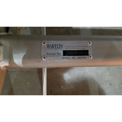 Silver metallic cylindrical tube with barton medical corporation label on the barton convertible medical chair
