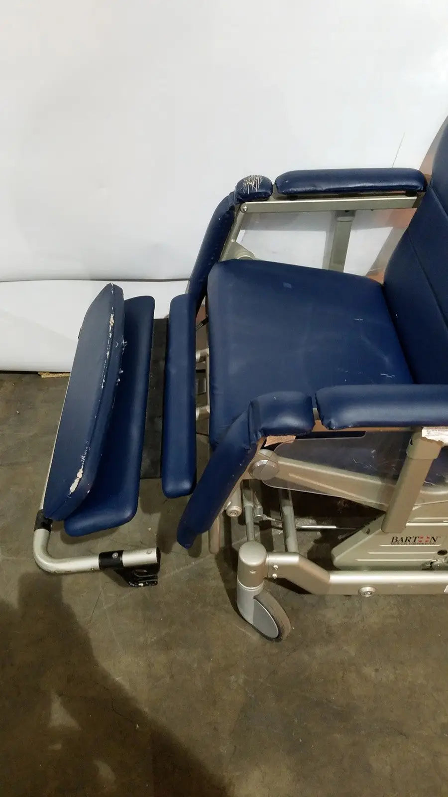 Blue upholstered barton convertible medical chair with silver metal frame and wheels for patient comfort