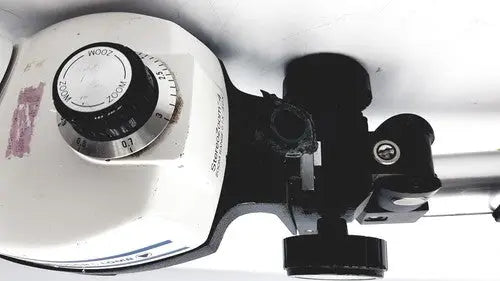 White and black bausch and lomb stereozoom 4 microscope with circular dial and zoom range 0.7x to 3.0x for reuse medical tasks