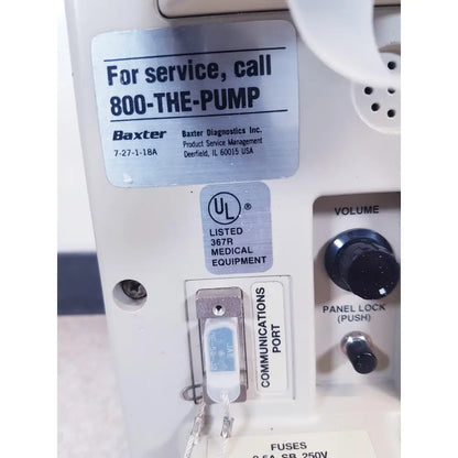 White plastic baxter 2m8063 volumetric infusiion pump with silver label black volume and panel lock knobs and communication port