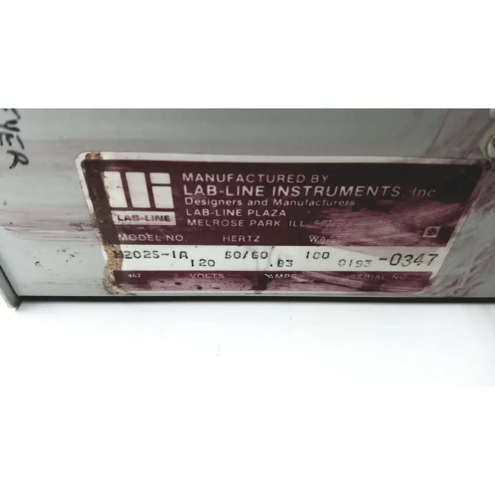 A weathered brown metal label with white text from baxter scientific products h2025-1a multi-blok heater