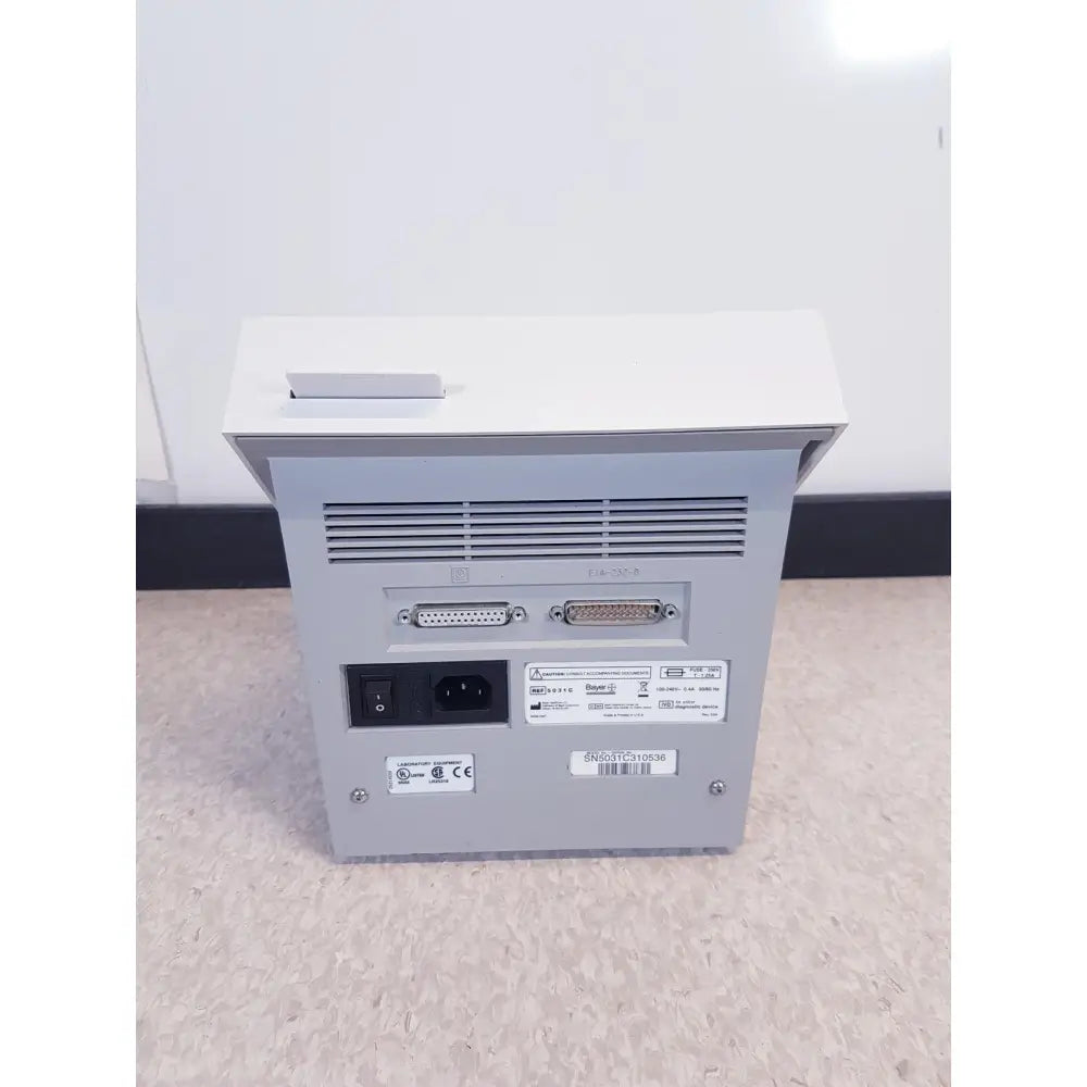 Rear view of gray metallic bayer dca 2000+ analyzer ref featuring two d-sub connectors and ac power input for reuse medical