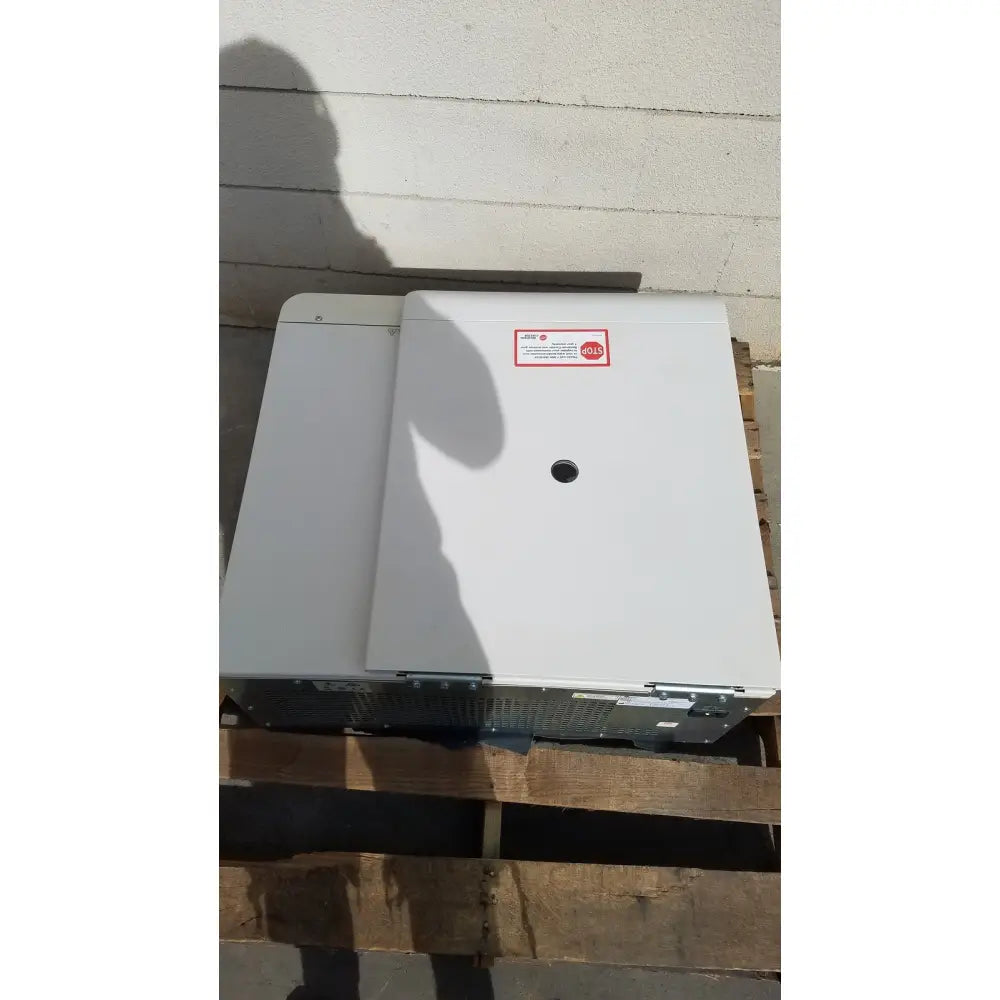 White rectangular industrial-grade electrical panel with red hold sticker on beckman coulter avanti refrigerated centrifuge
