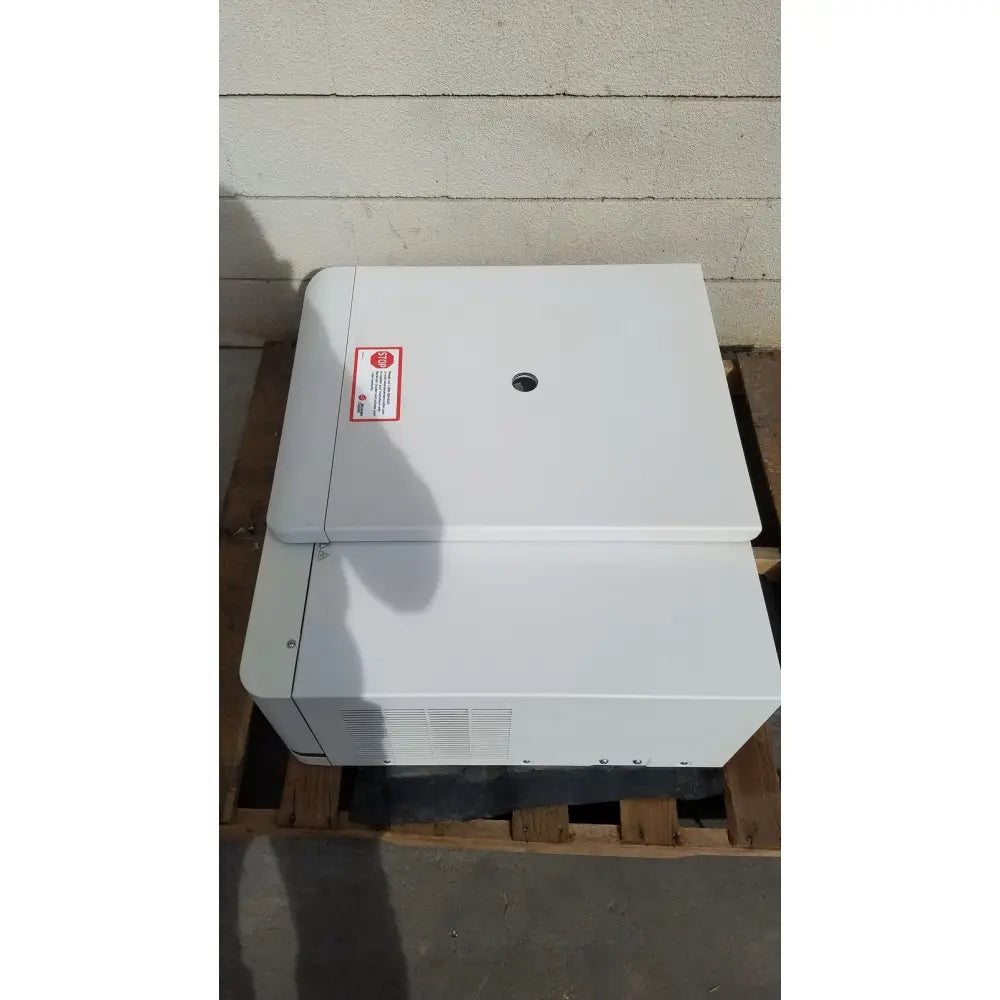 White industrial-grade beckman coulter avanti j-15r refrigerated centrifuge with red warning label and circular vent on top