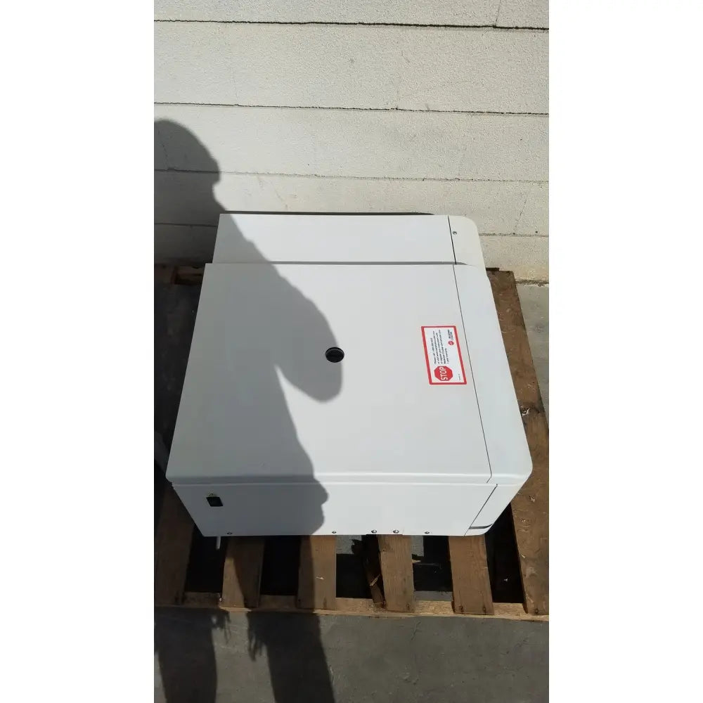 White rectangular industrial printer box with red warning label and black vent on top of beckman coulter avanti j-15r refrigerated centrifuge