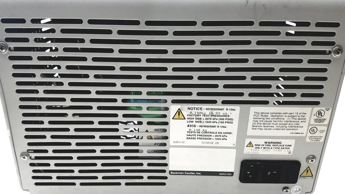 Silver metallic beckman coulter microfuge 22r server rack with perforated grille and multiple warning labels visible from back side