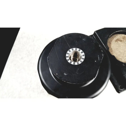 Black circular mechanical component with a central metallic ring and alternating black and white segments for beckman coulter ultracentrifuge
