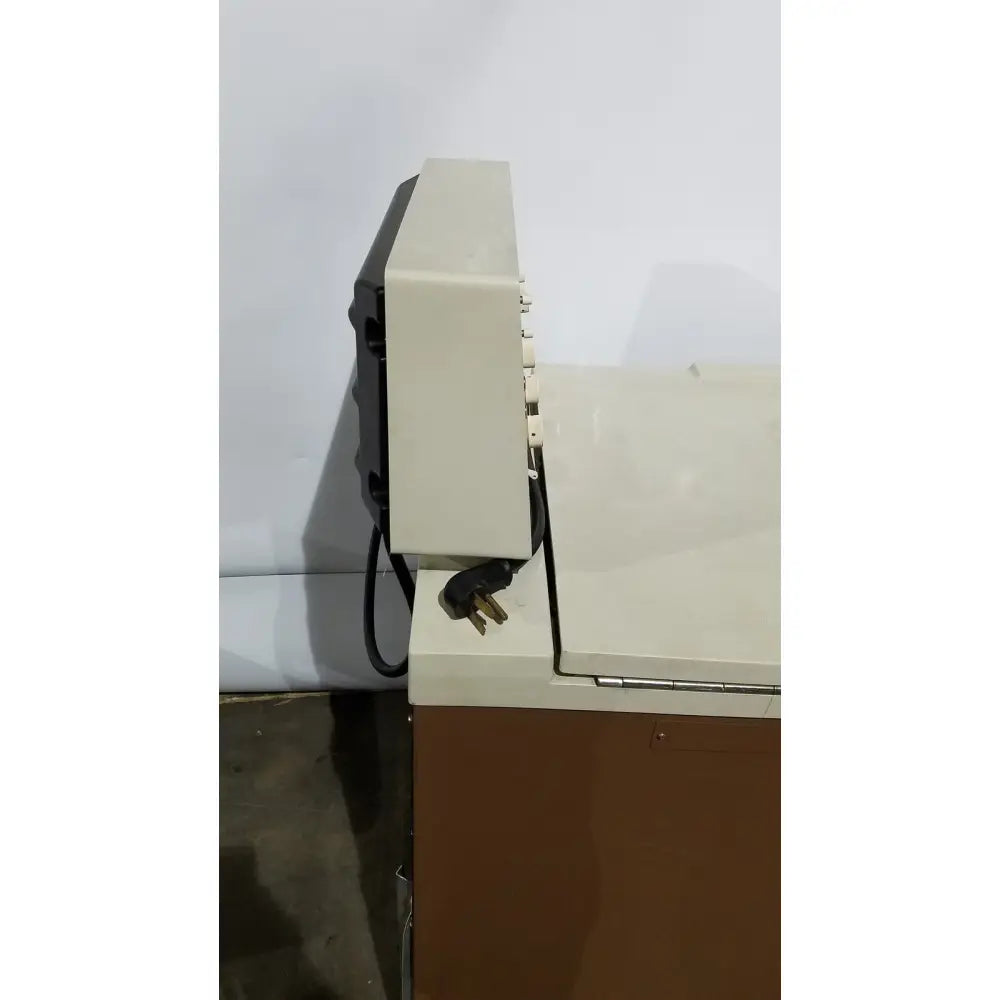 Beige and black beckman j2-21 refrigerated centriifuge showing power cord plugged into side of device