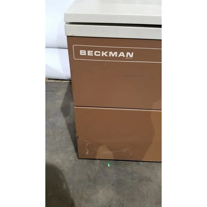 Brown beckman two-drawer filing cabinet with white top alongside beckman j2-21 refrigerated centrifuge unit