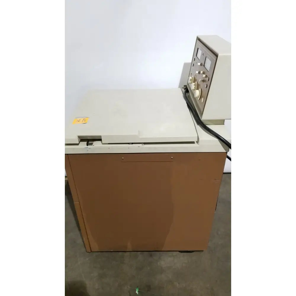 Beige and brown beckman j2-21 refrigerated centriifuge with control panel featuring dials switches and gauges