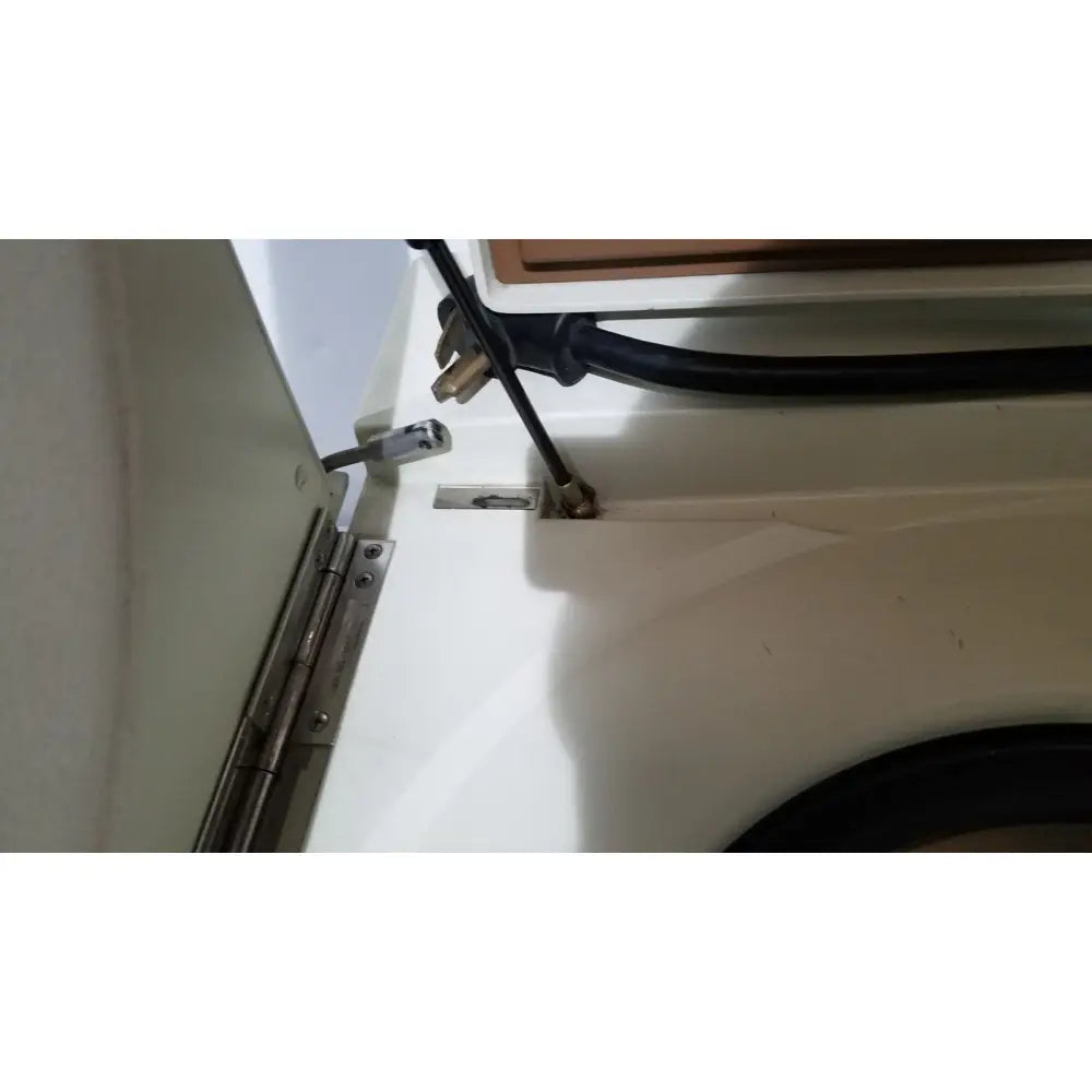 Black power cord with metallic plug attached to the back of a beckman j2-21 refrigerated centriifuge appliance