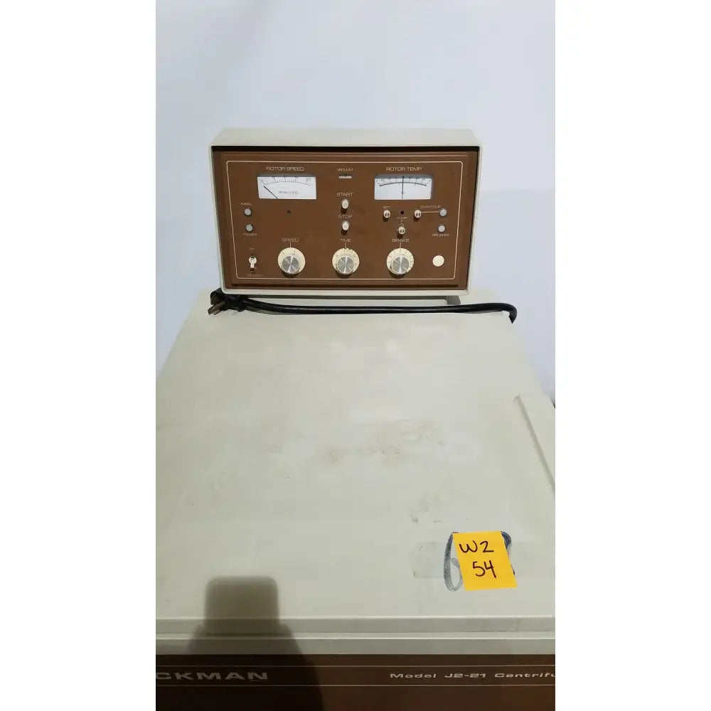 Beige and brown beckman j2-21 refrigerated centriifuge with analog meters rotary knobs and control buttons on front panel