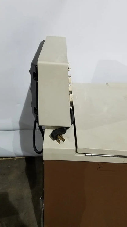 Beige and black beckman j2-21 refrigerated centriifuge showing power cord plugged into side of device