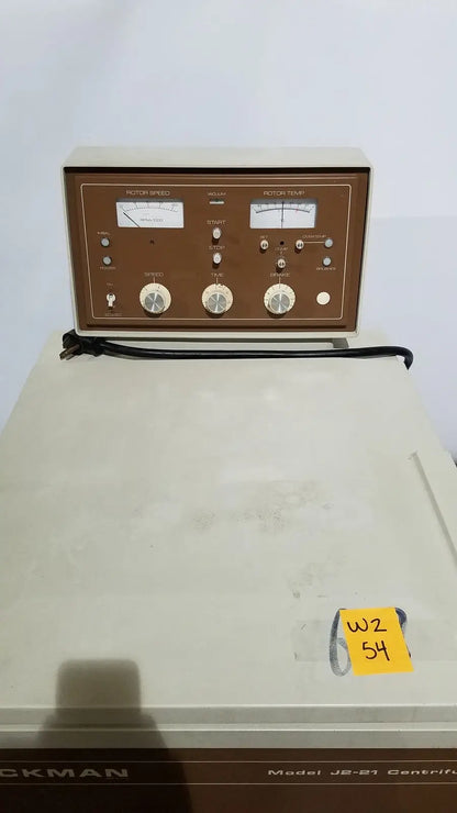 Beige and brown beckman j2-21 refrigerated centriifuge with analog meters rotary knobs and control buttons on front panel
