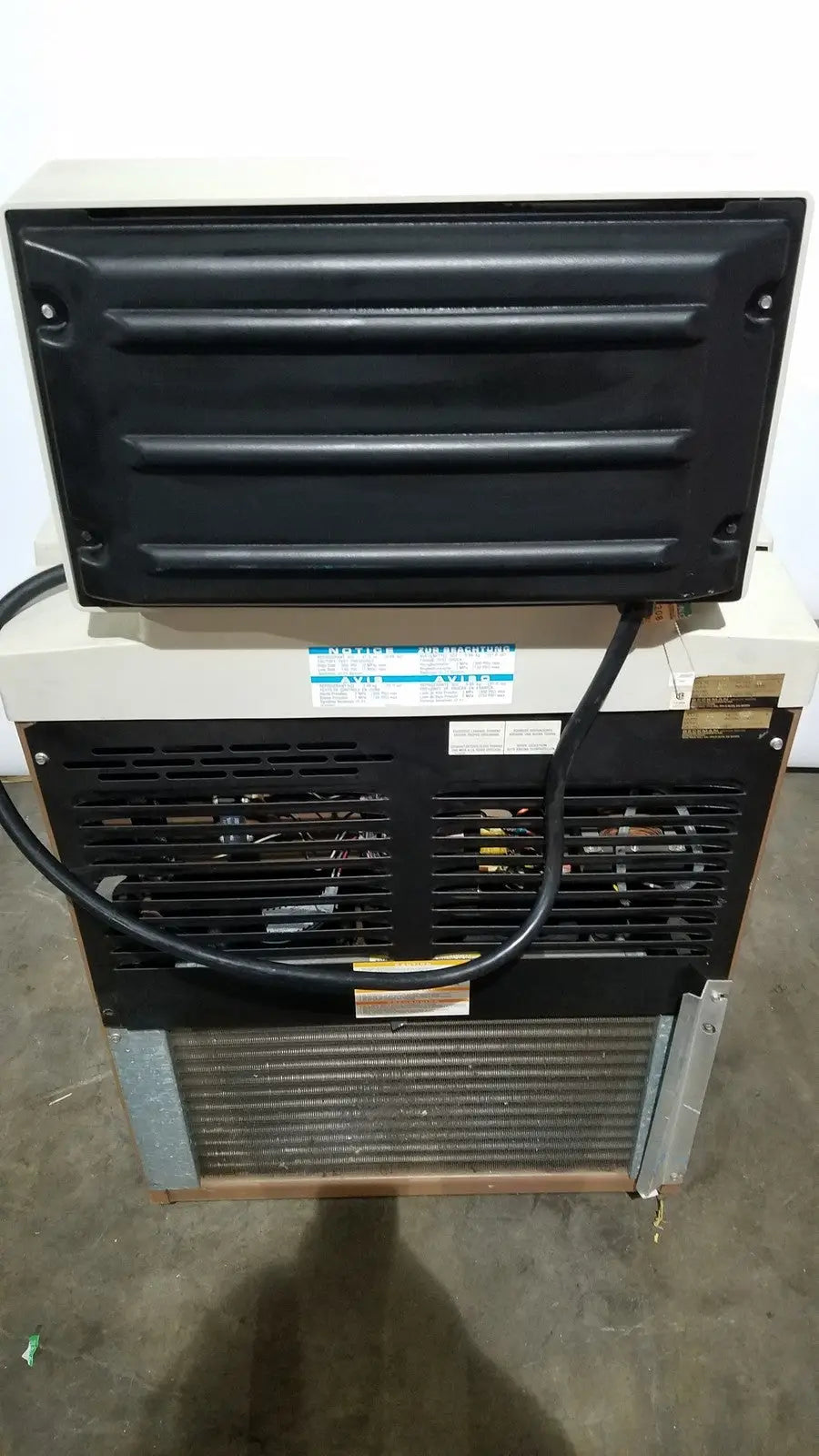 Black and beige beckman j2-21 refrigerated centriifuge rear side with ribbed panel metal grille and visible internal components