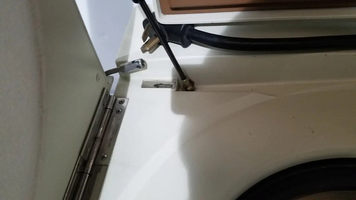 Black power cord with metallic plug attached to the back of a beckman j2-21 refrigerated centriifuge appliance
